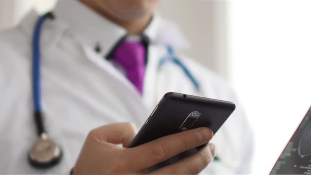 Medical doctor radiologist view MRI scan and typing SMS to somebody. 4K UltraHD video