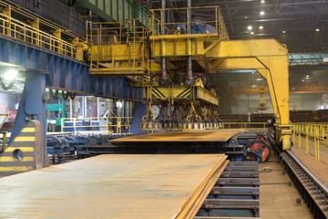 Overhead crane with magnetic lift in the shop for manufacturing large diameter pipes