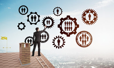 Businessman on house roof presenting teamwork and connection concept. Mixed media