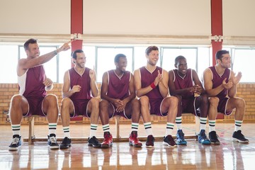 Excited basketball player sitting on bench
