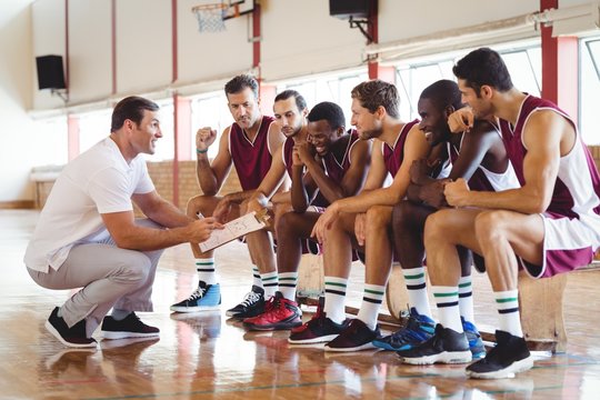 Coach explaining game plan to basketball players