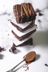 Pieces of chocolate baked brownies in a stacked pile. Gourmet concept.
