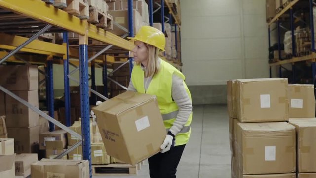 Woman warehouse worker unloading boxes.
