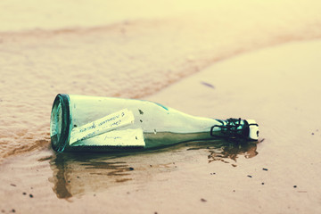 bottle with message on the beach shore sand