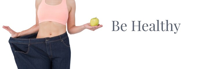 Fototapeta premium Be healthy text and fit woman holding apple in oversized