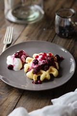 Waffle con crema allo yogurt e frutti di bosco su tavolo in legno
