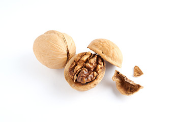 Walnuts and walnuts kernels with shell crumbles isolated on white background.