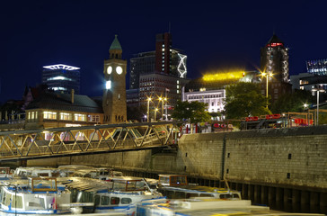 Fototapeta na wymiar historischer Hafen in Hamburg mit Schiffen und Docks im Hintergrund und Hafenanlage mit Glockenturm in Deutschland Europa bei Nacht