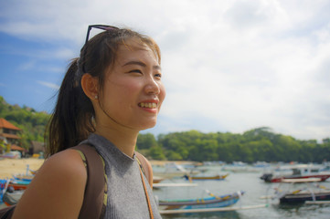  happy Asian Chinese woman with backpack in beach trip tourist excursion smiling sweet in Summer holiday and vacation travel