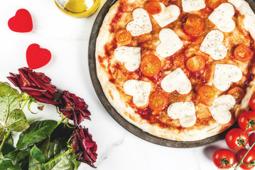 Valentine holiday food concept, pizza margarita with heart shaped cheese, white marble background, copy space top view, with roses