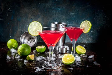 Tuinposter Red cosmopolitan cocktail with lime in martini glass, on dark rusty background copy space © ricka_kinamoto