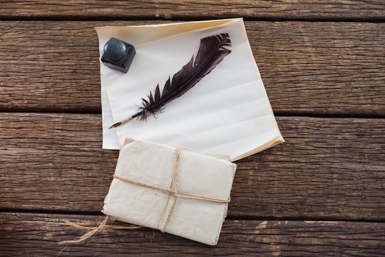Quill feather, ink pot, and legal documents arranged on table - Powered by Adobe