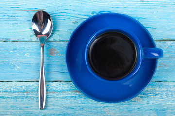 Cup of coffee, spoon on a wooden background. Top view