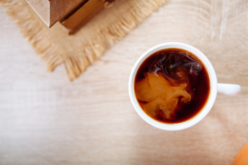 Coffee with milk, on a wooden table.