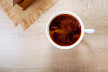 Coffee with milk, on a wooden table.