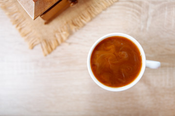 Coffee with milk, on a wooden table.