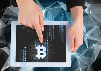 Bitcoin icon and interface on tablet in hands