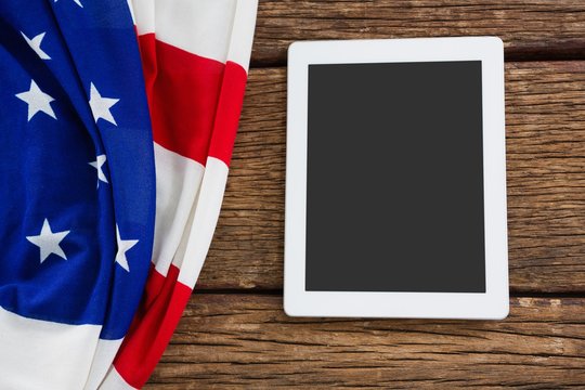 American flag and digital tablet arranged on wooden table - Powered by Adobe