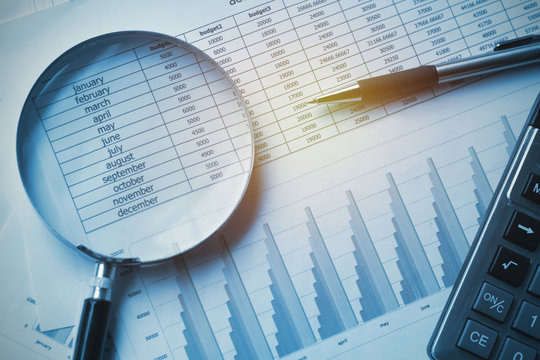 business documents accounting with calculator, pen and magnifying glass. concept for financial