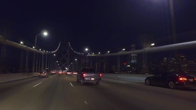 night driving across old section of Oakland Bay Bridge towards view of downtown SF