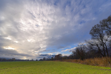 Vista panoramica di campagna, con cielo azzurro e nuvole bianche e grigie