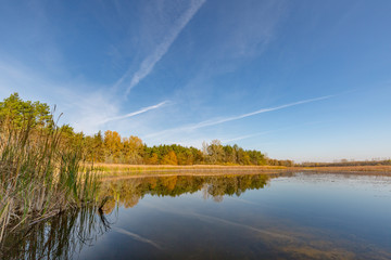 Autumn colorful landscape and lake reflection and blue sky