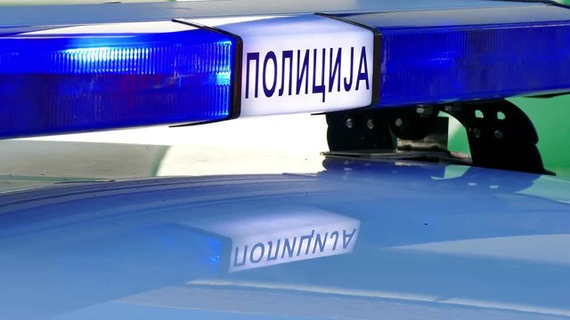 Blinking Strobe Lights on Police Car ; Blinking blue lights on a police car at the scene of a traffic accident.Cyrillic inscription