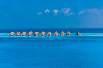 Maldives island aerial landscape view.  Beautiful blue sea and luxury water villas. Seaplane aerial view of Maldives atoll and coral reef