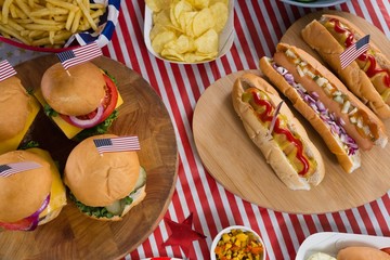Hot dogs and burgers on wooden table with 4th july theme
