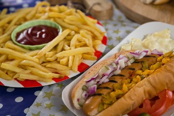 Hot dog and french fries on wooden table with 4th july theme