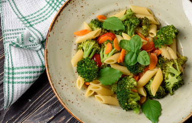 Italian home cooking. Vegetable pasta with broccoli, cherry tomatoes, carrots, garlic and basil. Top view