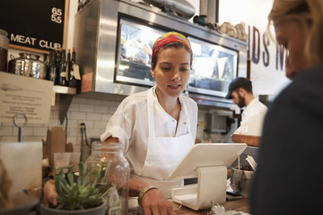 Fototapeta na wymiar Young woman serving a customer in a butcher's shop