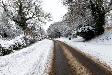 Obraz premium Snow covered road through a small village