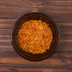 Saffron in a bowl on a wooden background