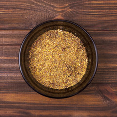 Spice mix - paprika, dried onions, white mustard, caraway seeds, black pepper in a bowl on a wooden background