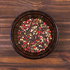 Pepper mix in a bowl on a wooden background