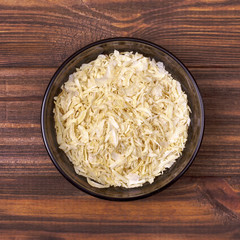 Dried onion in a bowl on a wooden background