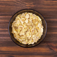 Dried garlic in a bowl on a wooden background