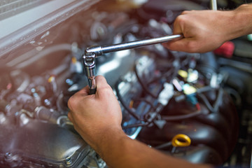 Hands of mechanic working in auto repair shop

