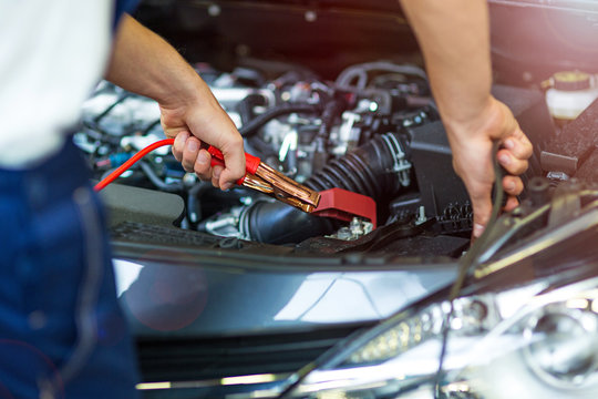 Mechanic using jumper cables to start a car
