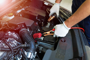 Mechanic using jumper cables to start a car
