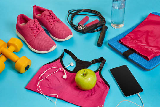 Flat lay of dumbbell, bottle of water, jump rope and sneaker, sport equipments, fitness items, top view © nazarovsergey