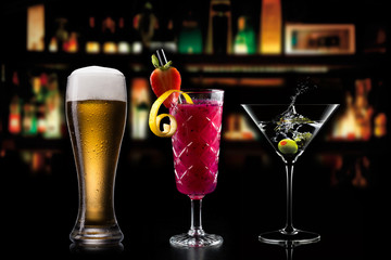 Selection of cocktails martini spritz bramble gin tonic beer bramble bar blurred black background