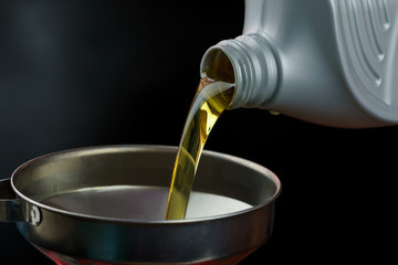 Engine oil pouring on black background. 
