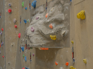 Indoor climbing wall closeup with grips and securing belt.