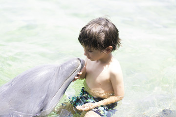 Vacation Lifestyle -Happy Boy hugging a dolphin