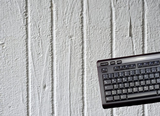 Keyboard of a computer exposed isolated in front of a white painted concrete wall
