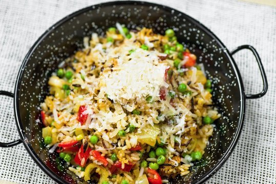 Risotto with vegetable on rustic spotted pan.