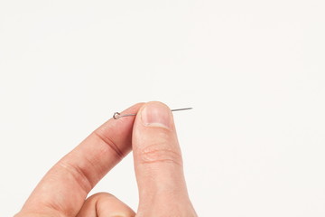 Sewing needle in hand on white background