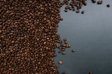 Coffee beans on the dark grey background, half